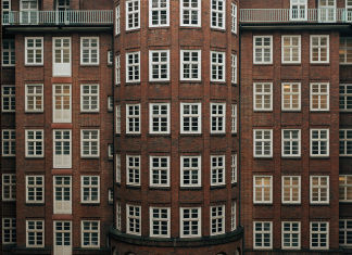 Ein Jahr Wohngeld-Plus: Doppelt so viel Geld und Empfänger Rotes Backsteingebäude von außen, in der Mitte eine Rundung, viele Fenster