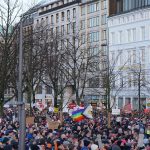 Demo gegen Rechts wegen Überfüllung abgebrochen Viele Menschen stehen vor Gebäuden uns haben Plakate mit Aufschriften.