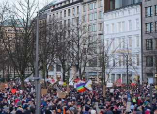 Demo gegen Rechts wegen Überfüllung abgebrochen Viele Menschen stehen vor Gebäuden uns haben Plakate mit Aufschriften.