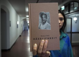 Bin ich hässlich? Vordergrund Buch Hässlichkeit von Moshtari Hilal; hintergrund Lena Gaul um Flur hält das Buch