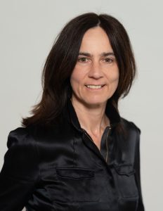 Martina Zurhold vom Verein Rockcity Hamburg e.V. ist mit einem schwarzen Oberteil vor einem grauen Hintergrund zu sehen.