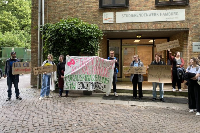 Studierende mit Plakaten vor dem Studierendenwerksgebäude der UHH gegen die Erhöhung der Semesterbeiträge