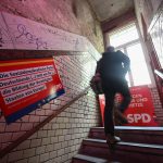 Rasierklinge hinter Wahlplakat verletzt Hamburger SPD-Politiker Mann läuft an Wahlplakaten der SPD vorbei.