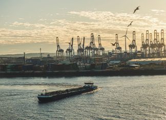HHLA meldet Verluste Ein Containerschiff auf der Elbe, im Hintergrund der Hamburger Hafen