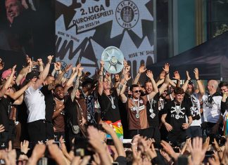 „Scheiß aufs Wetter, wir machen weiter” Aufstiegsfeier FC St. Pauli. Jackson Irvine (mit Meisterschale) und die Mannschaft feiert auf der Bühne auf dem Spielbudenplatz auf der Reeperbahn