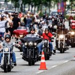 Tattoos und BBQs auf den Hamburg Harley Days 2024 Hamburg Harley Days: Eine Gruppe Motorradfahrer*innen fährt auf einer abgesperrten Straße.