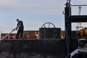 Mann auf Schiff zieht Taue fest. Foto: Karoline Gebhardt
