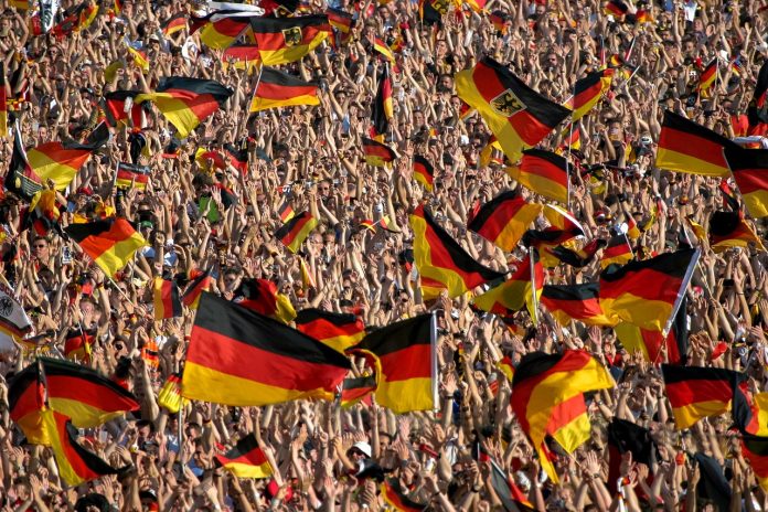 Jubelnde Menschenmenge, die Deutschlandflaggen schwingen