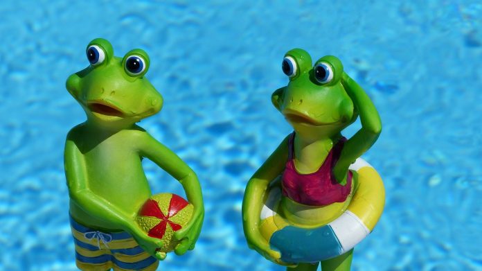 Die Freibäder öffnen: Zwei Froschfiguren stehen vor einem Pool.