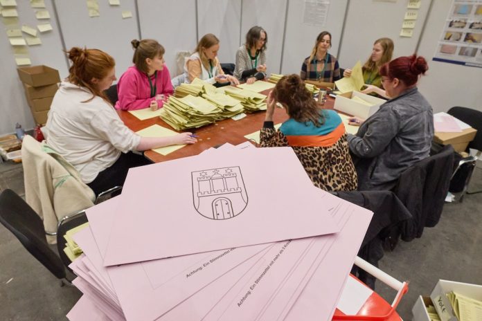 Wahlhelferinnen in den Messehallen zählen nach der Bezirkswahl Hamburg die Stimmen aus.