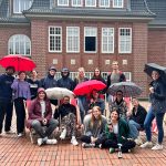 Sommerpause: Die Finken klinken sich aus Sommerpause: Redakteur*innen von FINK.HAMBURG stehen draußen mit Regenschirmen.