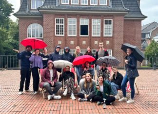 Sommerpause: Die Finken klinken sich aus Sommerpause: Redakteur*innen von FINK.HAMBURG stehen draußen mit Regenschirmen.