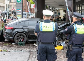Ermittlungen nach tödlichem Unfall am Jungfernstieg Verkehrsunfall am Jungfernstieg: Polizisten stehen an einem demolierten Auto vor einer Sparkasse in der Hamburger Innenstadt. Ein Auto ist in Hamburg in eine Sparkasse gefahren, es gab mehrere Verletzte.