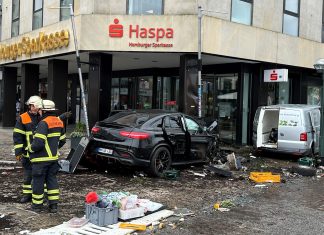 Auto fährt in HASPA-Filiale am Jungfernstieg Helfer*innen stehen an einem demolierten Auto vor einer Sparkasse. Ein Auto ist in Hamburg in eine Sparkasse gefahren, es gab mehrere Verletzte.