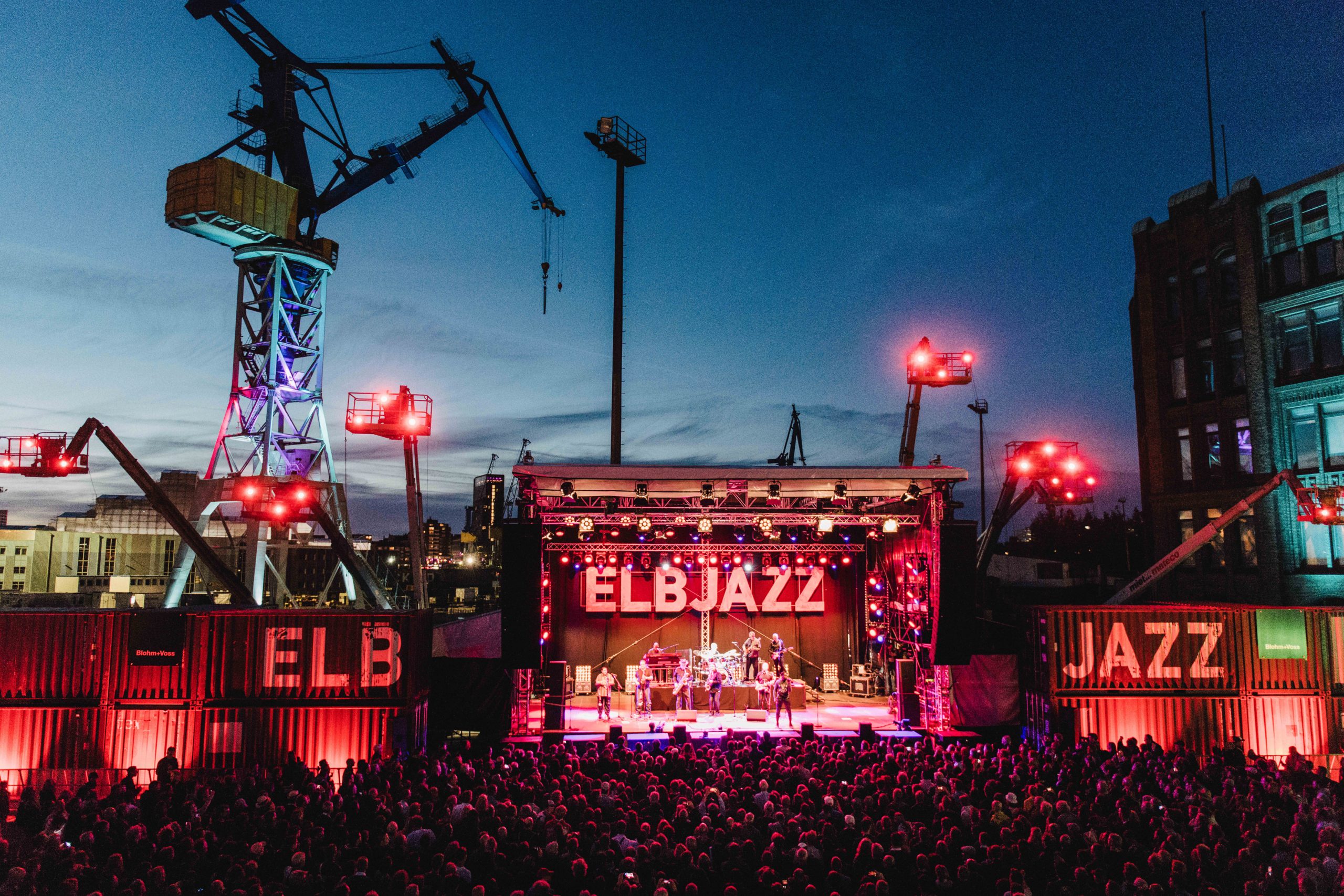 Beleuchtete Bühne des Elbjazz Festivals vor der Hamburger Hafenkulisse.