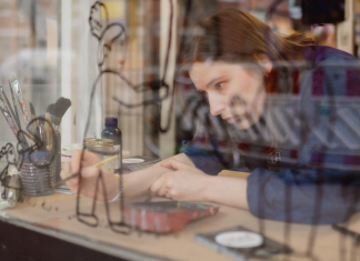 Mehr als nur Symbole: Ein Gespräch über Emojis und ihre Geschichte Illustratorin Karla-Jean v. Wissel arbeitend in einem Schaufenster.