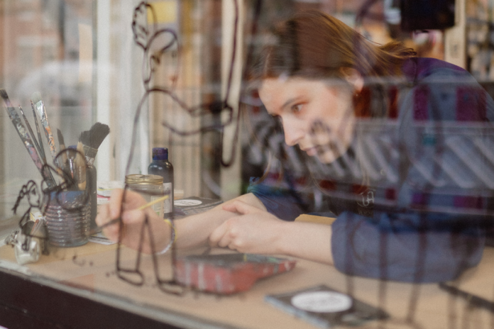 Illustratorin Karla-Jean v. Wissel arbeitend in einem Schaufenster.