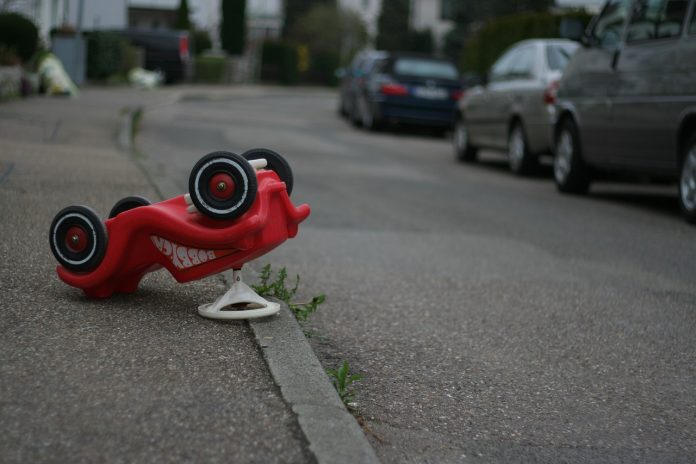 Bobbycar umgedreht an der Straße liegend