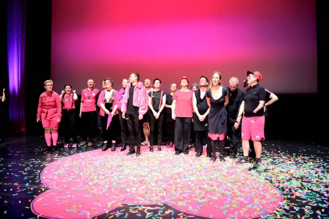 Eine Gruppe pink schwarz angezogener Menschen auf einer Kinobühne beim Hamburg International Queer Film Festival.