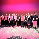 Hamburg International Queer Film Festival startet Eine Gruppe pink schwarz angezogener Menschen auf einer Kinobühne beim Hamburg International Queer Film Festival.