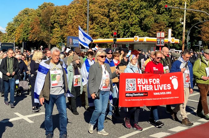 Hamas Angriff: Hunderte Menschen demonstrieren anlässlich des ersten Jahrestages des Überfalls der Hamas auf Israel mit einem Banner mit der Aufschrift «Run for their lives» für die Freilassung der von der Hamas in Gaza festgehaltenen Geiseln. Foto: Markus Klemm/dpa +++ dpa-Bildfunk +++