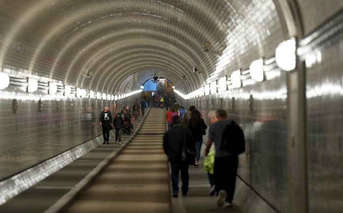 Passanten gehen durch den Alten Elbtunnel in Hamburg