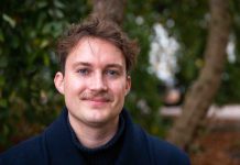 „Ich bin wütend, dass ich Demokraten oder Republikaner wählen muss” Dylan Johnson steht vor einem Baum an der Alster. Er guckt genau in die Kamera. Er hat einen Schnauzer und hellblaue Augen.