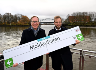 Moldauhafen! Neue U4-Haltestelle hat einen Namen U4-Erweiterung: Zwei Männer halten ein Schild mit der Aufschrift "Moldauhafen" in der Hand.