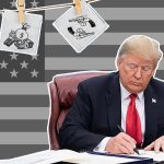 Trump is back: Was sind seine Pläne? Trump sitzt am Schreibtisch. Im Hintergrund ist die US-Flagge zu sehen.