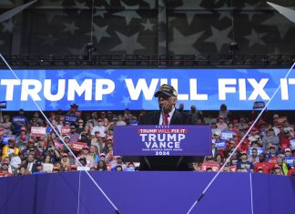 Trump schürt Zweifel an Wahlausgang Donald Trump bei einem Wahlkampfauftritt vor Anhängern. Im Hintergrund ist der Slogan "Trump Will Fix It!" zu sehen.