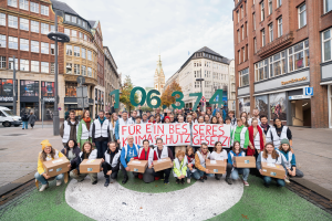 Volksentscheid: Viele Menschen vom Zukunftsentscheid stehen in Hamburg und halten die Zahl 106.374 hoch. 