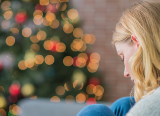 Stille Nacht, einsame Nacht Einsamkeit: Frau vor dem Weihnachtsbaum.
