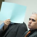 Zehn Jahre Haft für Milizenchef des Assad Regimes Der Verurteilte verdeckt sein Gesicht.