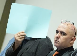 Zehn Jahre Haft für Milizenchef des Assad Regimes Der Verurteilte verdeckt sein Gesicht.