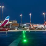 Hamburger Flughafen erwartet Hochbetrieb Ein Bild vom Flughafen Hamburg im Dunkeln. Man sieht verschiedene Flugzeuge, die auf dem Rollfeld stehen und bunte Lichter leuchten.