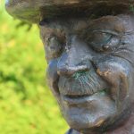 150 Jahre Thomas Mann: Große Feier zum Jubiläum Eine Thomas Mann Statue vor grünem Hintergrund.