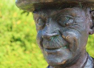 150 Jahre Thomas Mann: Große Feier zum Jubiläum Eine Thomas Mann Statue vor grünem Hintergrund.