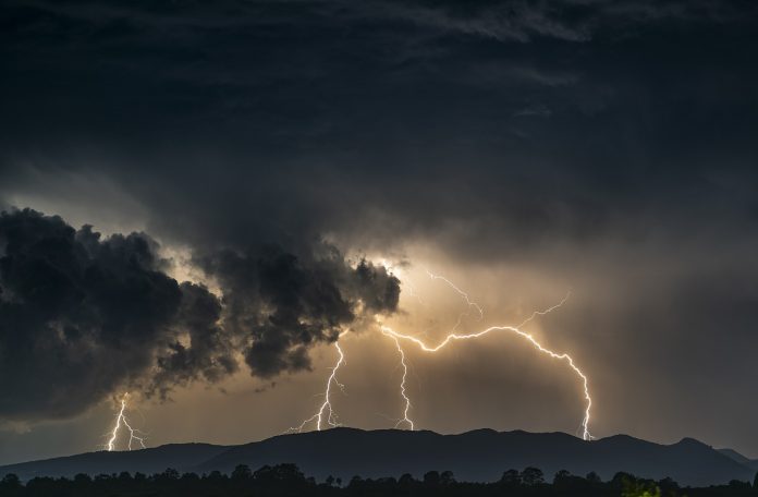 Ein dunkler Himmel mit Unwetter und Blitzen. Sturmböen in Hamburg erwartet.