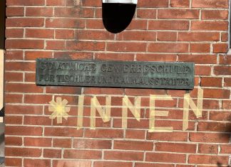 „Wir wollen die Stimme der Auszubildenden stärken“ Ein Schild der staatlichen Gewerbeschule für Tischler und Raumausstatter. Darunter in Kreppband angebracht: "*INNEN"