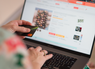 Jetzt kaufen, später bereuen: Warum immer mehr junge Menschen verschuldet sind Sinnbild für Jugendverschuldung: Eine Person kauft online ein und hält eine Kreditkarte in der Hand.