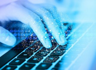 Digitale Behörde dank KI? Das planen Hamburgs Parteien Finger tippen auf einer Tastatur. Blauer Filter auf dem Bild. Verwaltung bald mit KI.