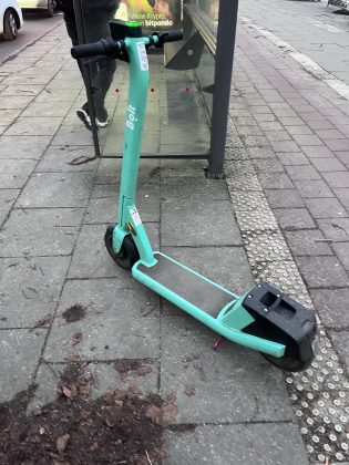 E-Roller auf dem Gehweg.