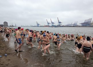 Eisbaden für den guten Zweck Zahlreiche Menschen gehen in der Elbe Eisbaden. Im Hintergrund ist ein Teil des Hafens zu sehen. Foto: Eisbademeisters Hamburg