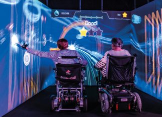 KI und Games zur Therapie: Hier zocken Senioren Seniorinnen sitzen in einem digitalen Spielwürfel.