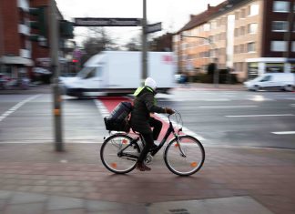 Radfahren in Hamburg: Zwischen Verkehrswende und Unfallstatistik Symbolbild für Radfahren in Hamburg. Ein Radfahrer auf einer Straße, der Hintergrund ist verschwommen.