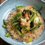 Veganuary in Hamburgs Mensen: Mehr pflanzliche Vielfalt im Januar Veganuary in den Haburger Mensen: Ein grüne Gemüsepfanne mit Erdnusssauce und Vollkornreis von oben fotografiert.