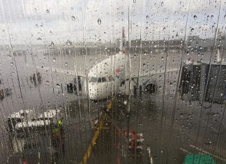 2024 war Rekordjahr am Hamburger Flughafen Hinter einer verregneten Scheibe steht ein Flugzeug an einem Flughafen.