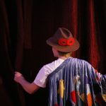 Hamburgs erste Kultur-WG verbindet Generationen Kind steht vor Theatervorhang.