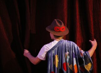 Hamburgs erste Kultur-WG verbindet Generationen Kind steht vor Theatervorhang.