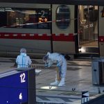 Mehrere Personen bei Messerattacke verletzt Ermittler in Schutzanzügen sichern Spuren an einem abgesperrten Bahnsteig vor einem ICE-Zug in einem Bahnhof. Der Bereich ist mit rot-weißem Band abgesperrt.